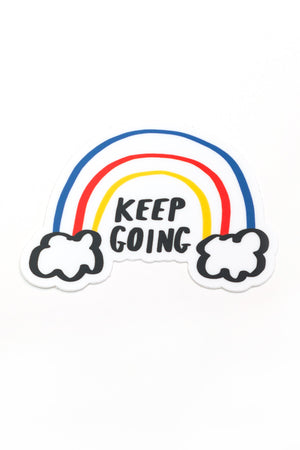 A die-cut sticker with a yellow, red, and blue rainbow emerging from fluffy clouds. The black text reads 