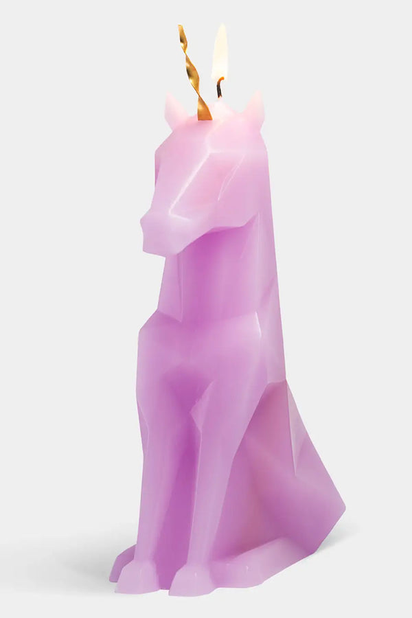 Geometric Unicorn wax candle  with a metal horn at the top. The wick is on fire on the top of the head. White background. 