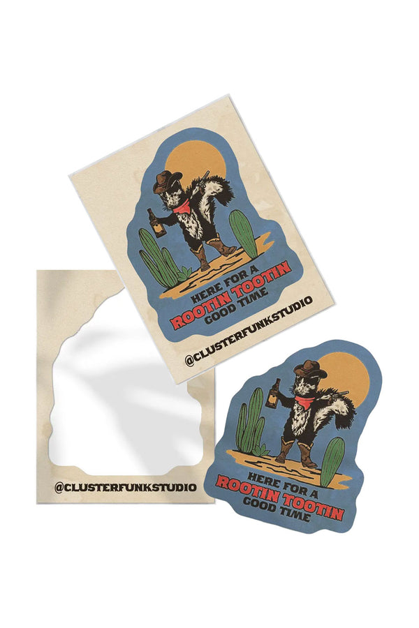 Peeled and unpeeled stickers featuring a cowboy raccoon holding whisky and a pistol, standing in between two cacti. The sticker says "Here for a rootin tootin good time" below the illustration in western text.