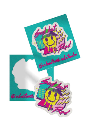 Stickers on a teal backing, peeled and unpeeled against a white backdrop. White sticker on a white background. Sticker features a melted smiley face wearing a bucket hat surrounded by various 90's style shapes in Aqua, purple, pink, and yellow. The sticker says Sad But Rad.