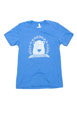 A royal blue t-shirt laying on a flat white surface. The shirt features white ink depicting a polar bear surrounded by laurel and a banner underneath that reads 