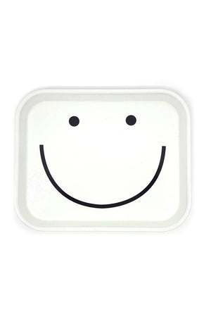 A white cafeteria-style tray with eyes and a smile in black ink.