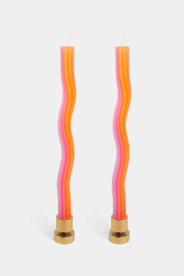 Tall votive candles in gold metal candle holder. The candles are in a squiggly shape with a pink and orange gradient color. Metal candle holders are not included. White background. 